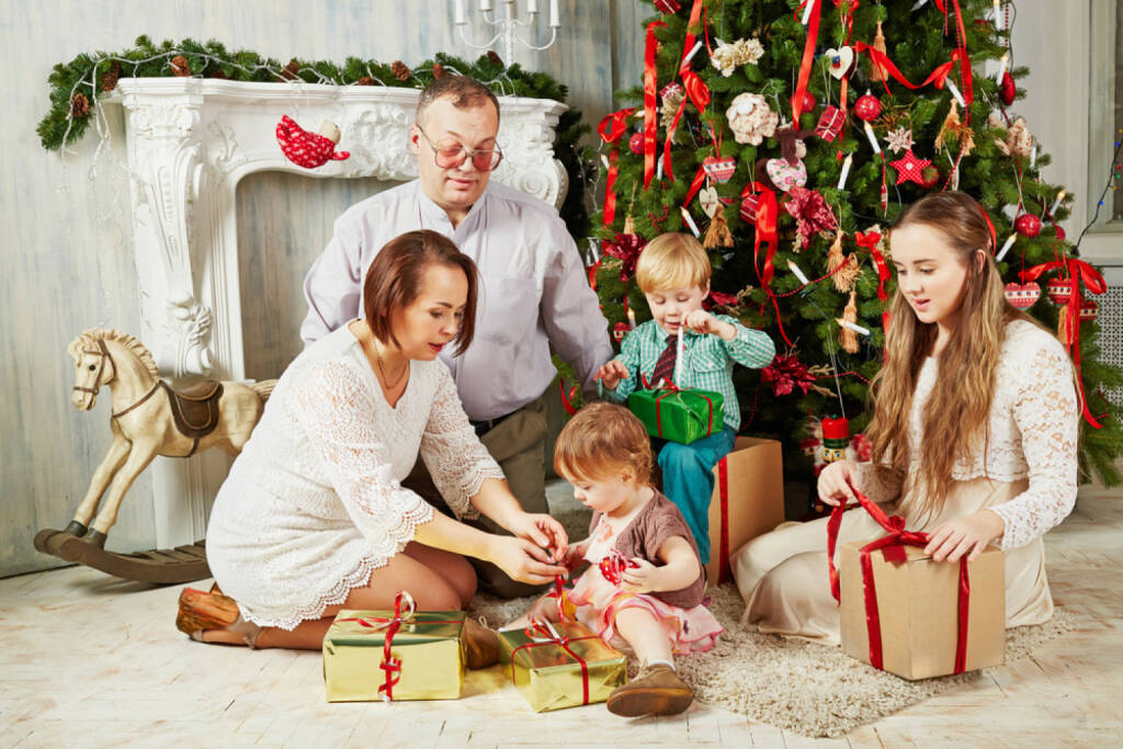 Weihnachten, USA, Bescherung, Geschenke, Heiliger Abend, http://www.shutterstock.com/de/pic-183709607/stock-photo-family-of-five-sits-near-christmas-tree-untying-ribbons-on-gift-boxes.html, © www.shutterstock.com (05.11.2014) 