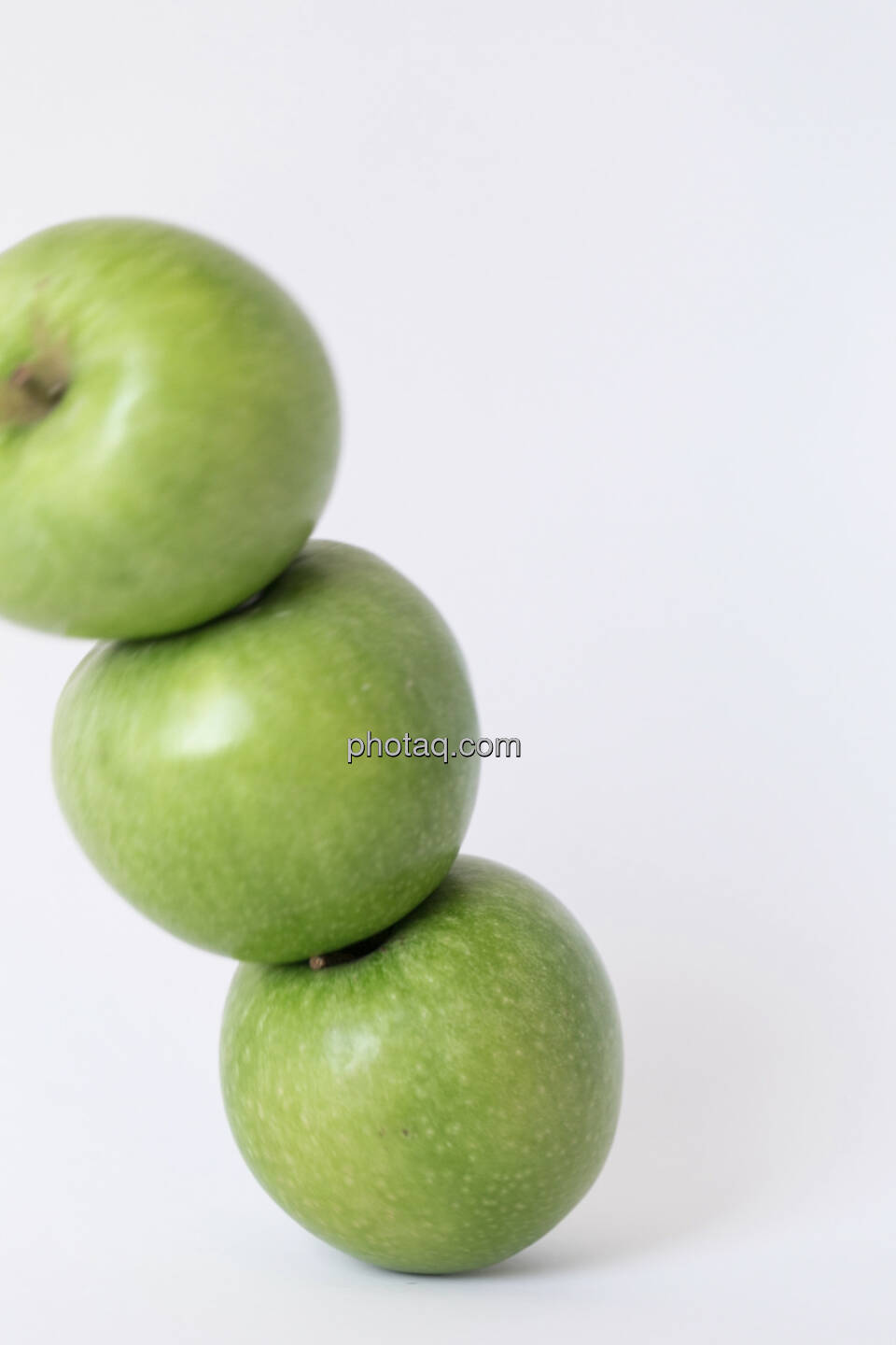 Der Apfel fällt nicht weit vom Stamm, 3 grüne Äpfel, gestapelt