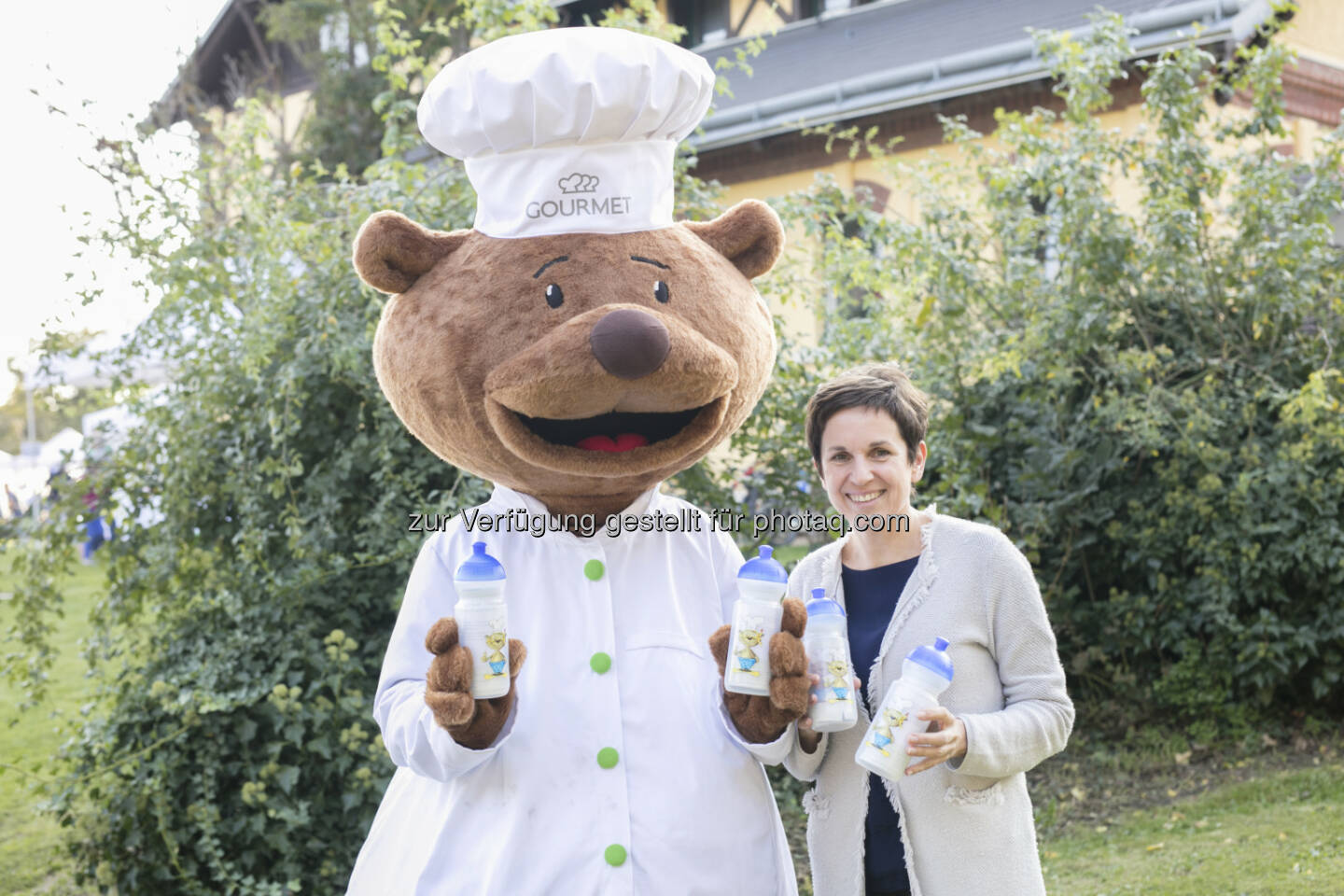 Mag.a Claudia Ertl-Huemer, GOURMET, Geschäftsfeldleiterin für Education & Care Catering und das Maskottchen Gourmelino mit der neuen Gourmelino-Wasserflasche - GOURMET: GOURMET: Gourmelino-Wasserflaschen für Wiener Schulkinder (Fotograf: Alek Kawka / Fotocredit: GOURMET)