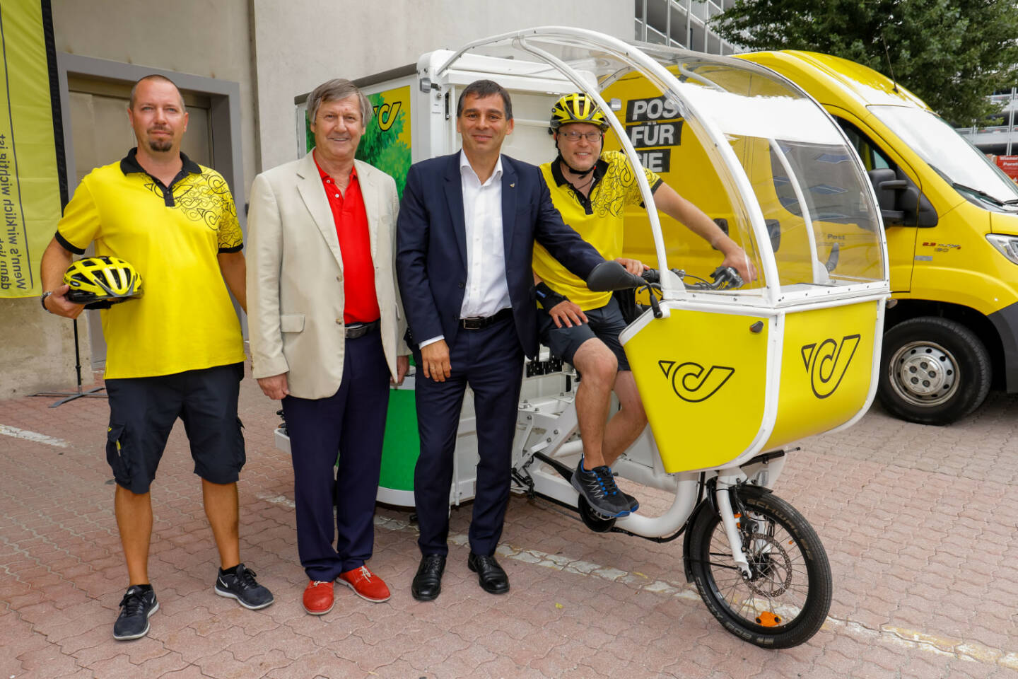 Österreichische Post AG: Pilotprojekt City Hub Wien im 3. Bezirk: Post testet neue Wege in der Zustellung; Erich Hohenberger, Bezirksvorsteher des 3. Wiener Gemeindebezirkes, Peter Umundum, Vorstand Paket & Logistik der Österreichischen Post AG und die beiden Zusteller bei der Vorstellung des Pilotprojektes City Hub Wien; Credit: Post