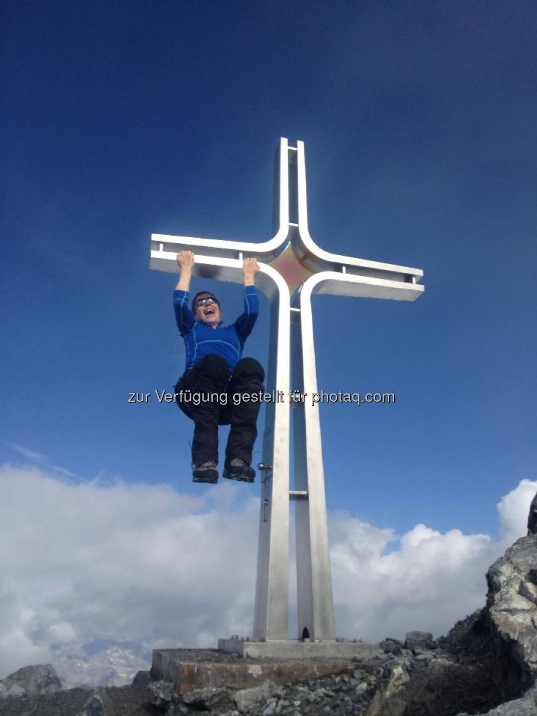 Berg: Henrike Brandstötter, Rosam Change Communications, scherzt mit dem Gipfelkreuz des Ortler
