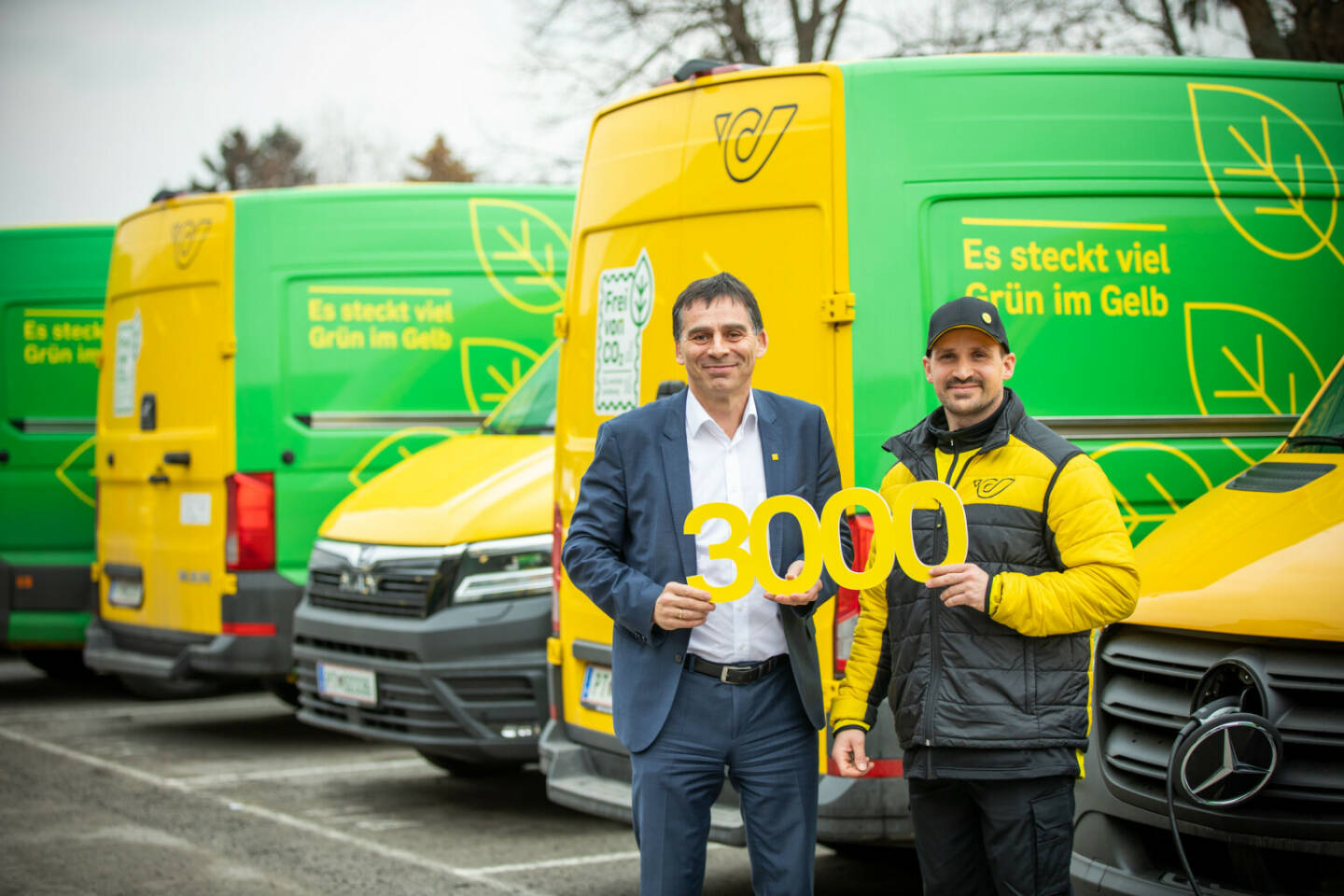Österreichische Post: Freude über das 3.000ste E-Fahrzeug der Post: Peter Umundum, Vorstandsdirektor für Paket & Logistik, mit einem der 40 Zusteller*innen, die in Wien bereits mit elektrisch betriebenen Pakettransportern unterwegs sind. Credit: Österreichische Post